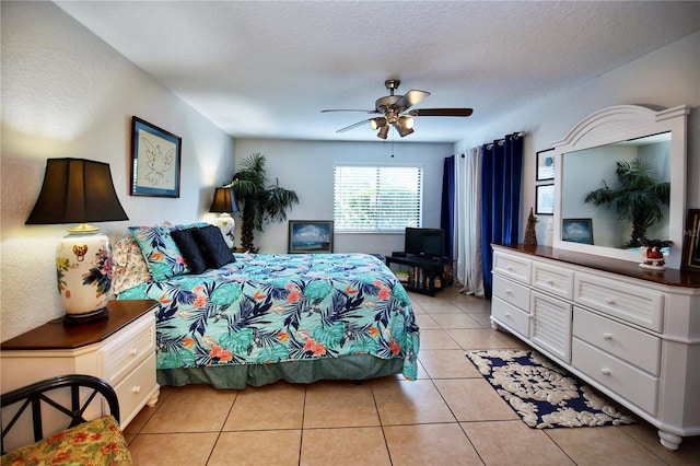 tiled bedroom featuring ceiling fan and a textured ceiling