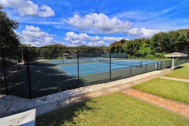 view of tennis court with a yard