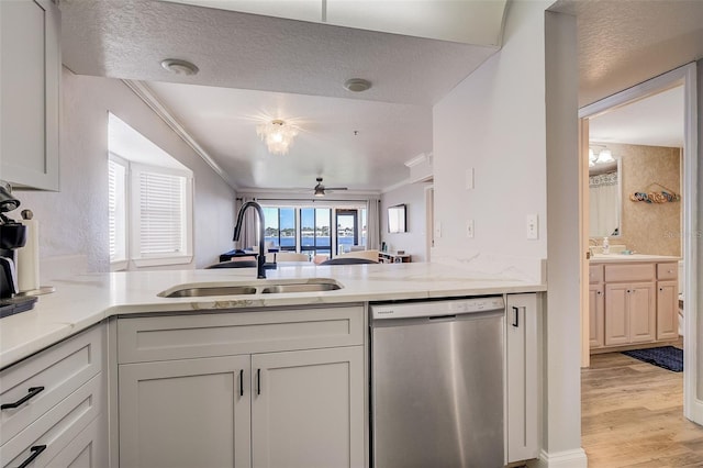 kitchen with light hardwood / wood-style floors, stainless steel dishwasher, sink, and ornamental molding