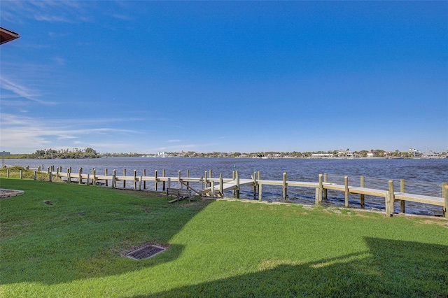 view of dock featuring a water view and a yard