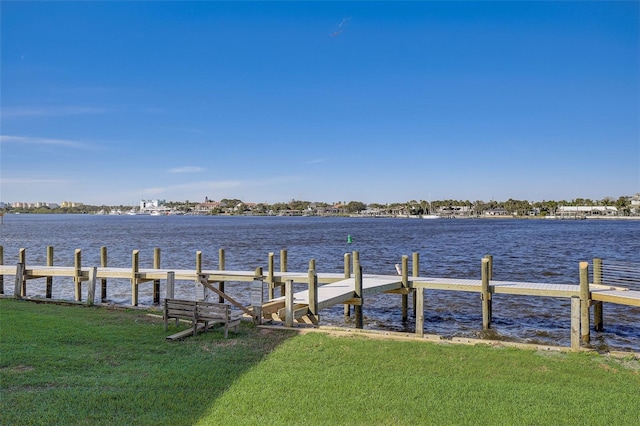 view of dock with a water view and a yard