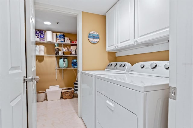 clothes washing area featuring light tile floors, cabinets, and separate washer and dryer