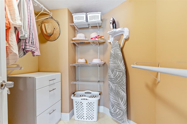 walk in closet with light tile floors