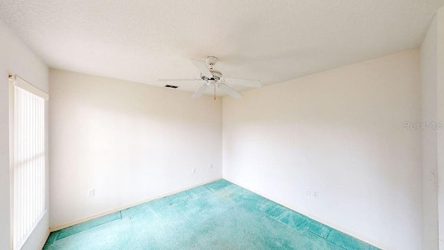 spare room featuring a textured ceiling, light colored carpet, and ceiling fan