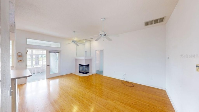 unfurnished living room with french doors, ceiling fan, and light wood-type flooring