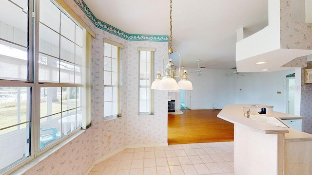 kitchen featuring light tile floors, decorative light fixtures, ceiling fan, and a healthy amount of sunlight