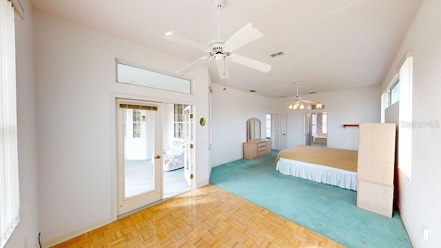 unfurnished bedroom with light parquet flooring, multiple windows, access to exterior, and french doors