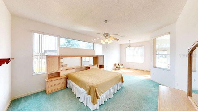 bedroom with a textured ceiling, carpet, and ceiling fan