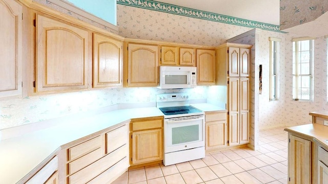 kitchen featuring light brown cabinetry, white appliances, and light tile flooring