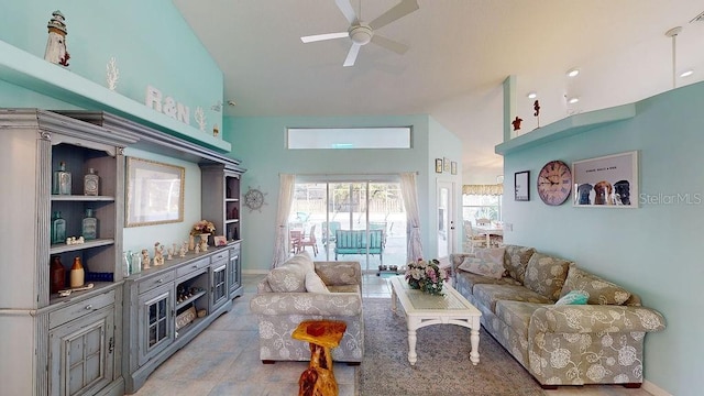 tiled living room with ceiling fan and high vaulted ceiling