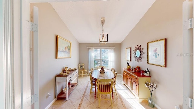 dining room with vaulted ceiling and light tile floors