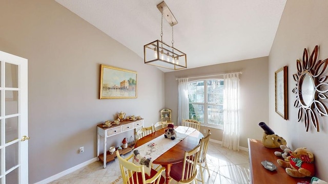 tiled dining space featuring lofted ceiling and an inviting chandelier