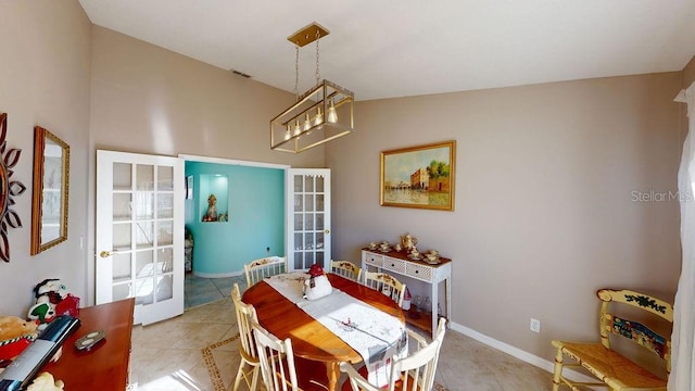 dining room with a notable chandelier, lofted ceiling, and light tile flooring