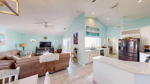 living room featuring high vaulted ceiling, ceiling fan, light tile floors, and sink