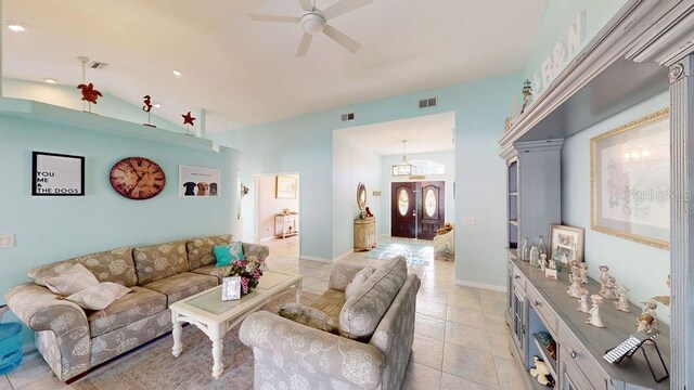 tiled living room with vaulted ceiling and ceiling fan with notable chandelier