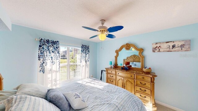 bedroom with light colored carpet, ceiling fan, and a textured ceiling