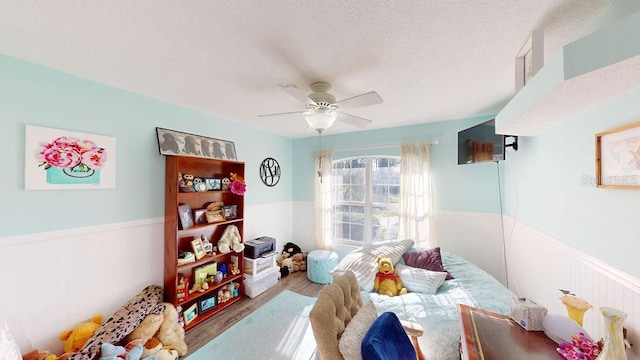 interior space with a textured ceiling, wood-type flooring, and ceiling fan