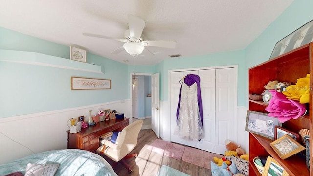 bedroom featuring ceiling fan, light hardwood / wood-style floors, and a closet