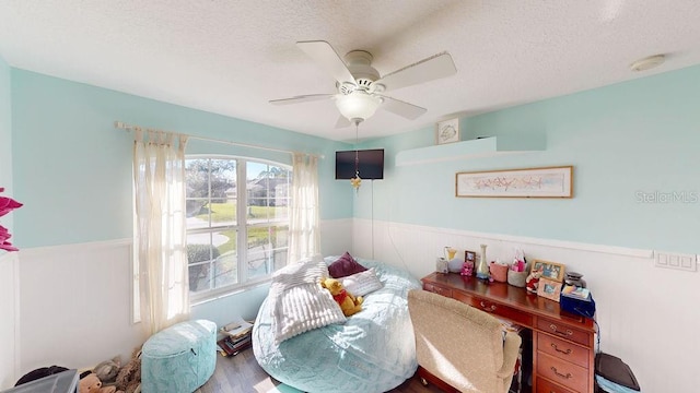 dining room featuring wood-type flooring, ceiling fan, and a textured ceiling