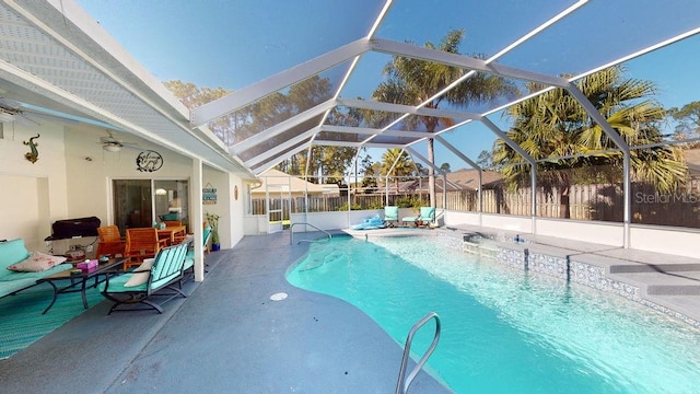 view of pool with a lanai, a patio, ceiling fan, and a hot tub