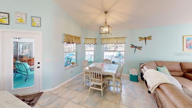 dining area featuring lofted ceiling, light tile flooring, and a notable chandelier