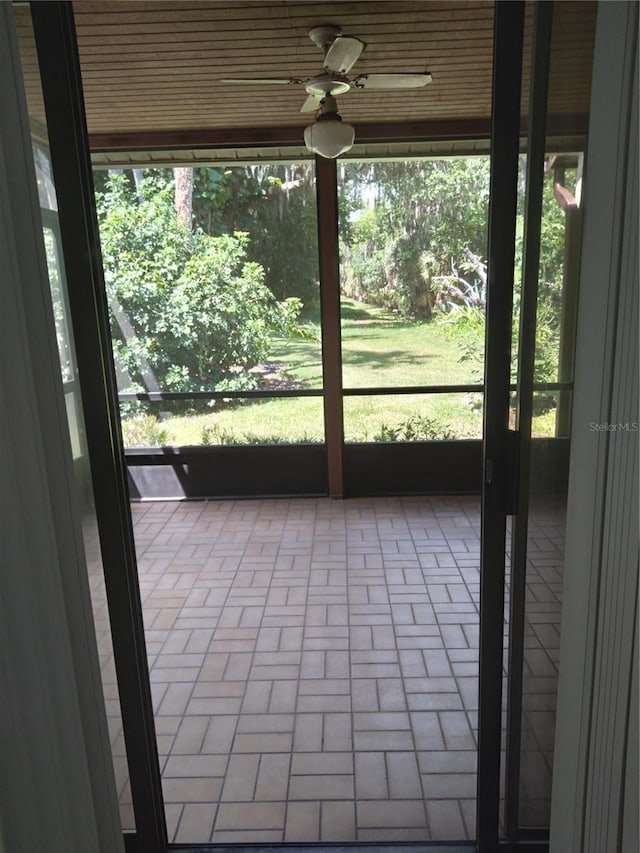 unfurnished sunroom featuring plenty of natural light and ceiling fan