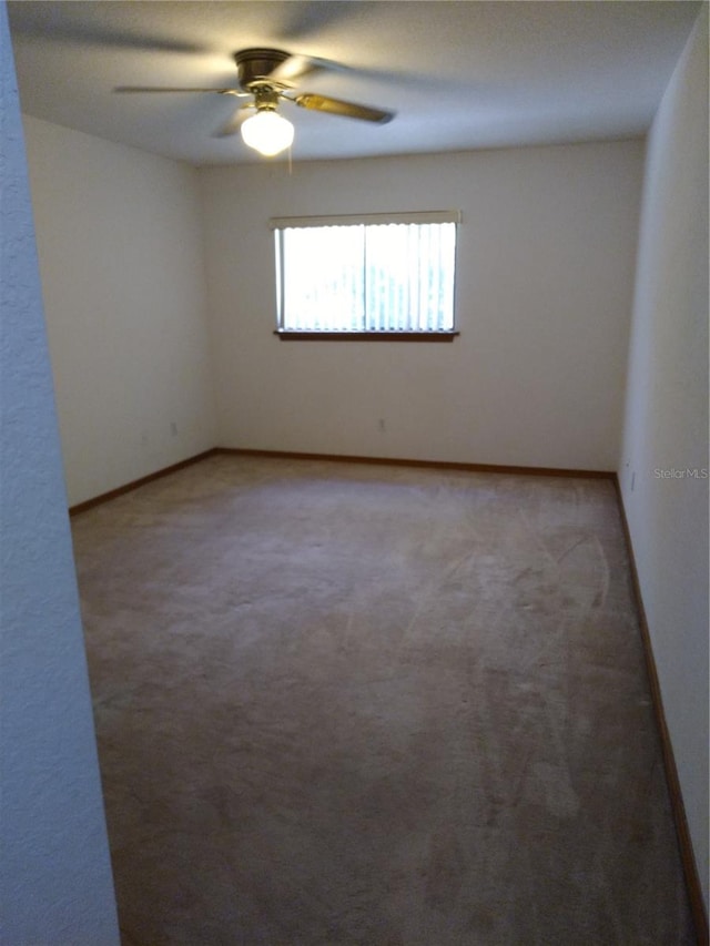 spare room featuring carpet and ceiling fan