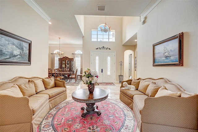 living room featuring crown molding, an inviting chandelier, light tile floors, and a high ceiling