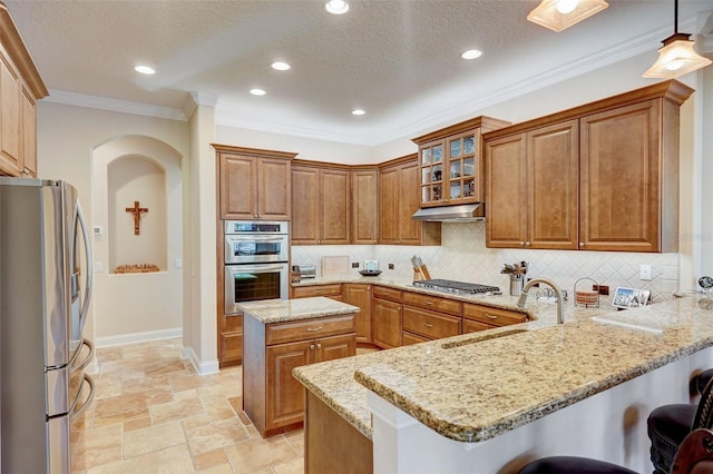 kitchen featuring tasteful backsplash, a breakfast bar area, appliances with stainless steel finishes, sink, and light stone counters