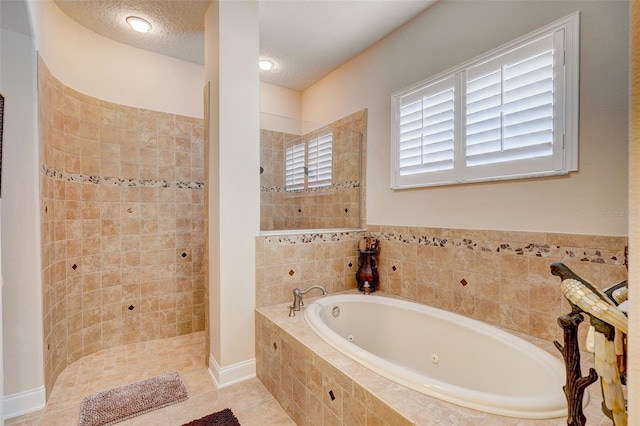 bathroom with tile flooring, a textured ceiling, and separate shower and tub