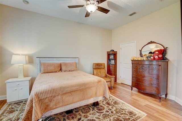 bedroom featuring a textured ceiling, light hardwood / wood-style floors, and ceiling fan