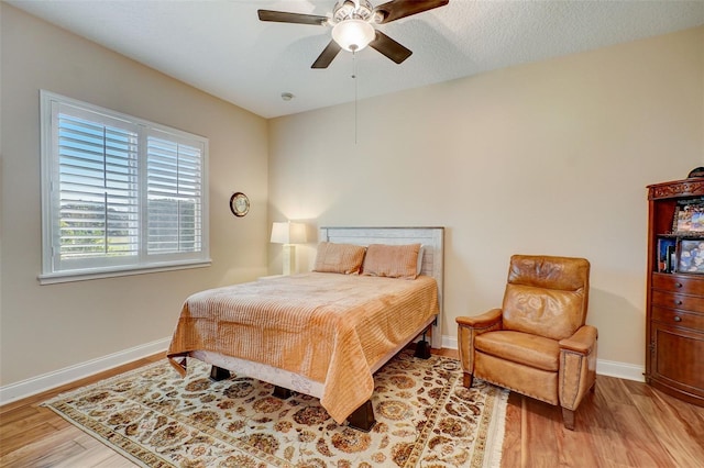 bedroom with light hardwood / wood-style floors and ceiling fan