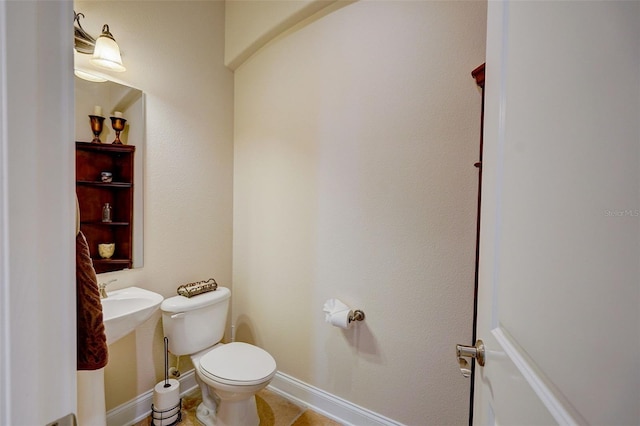 bathroom featuring tile flooring and toilet