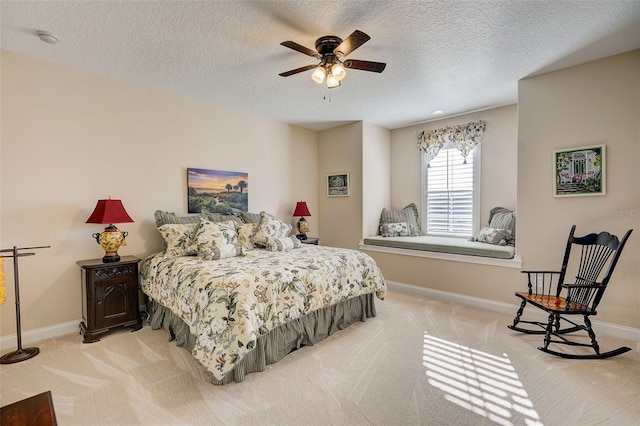 carpeted bedroom with a textured ceiling and ceiling fan