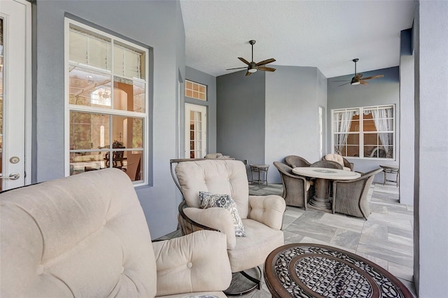 living room with light tile flooring, a textured ceiling, ceiling fan, and french doors