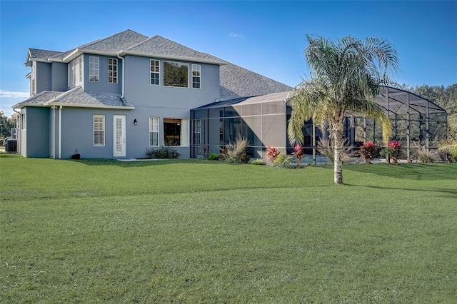 rear view of house with a yard, central AC, and glass enclosure