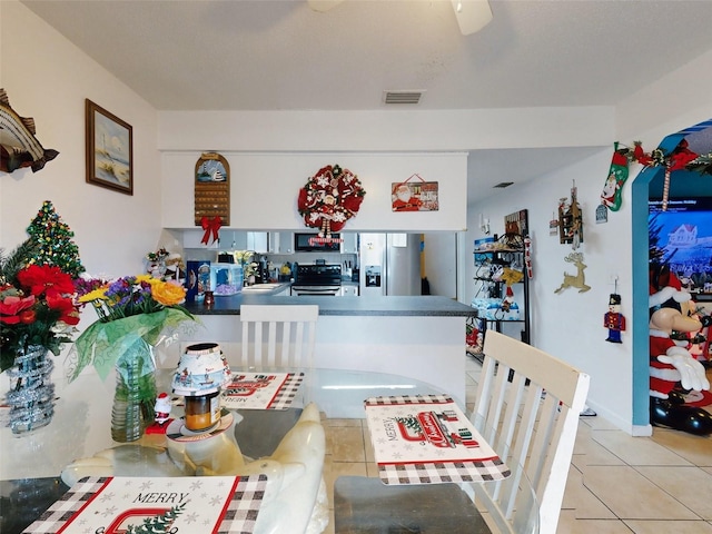 interior space featuring light tile flooring, ceiling fan, and sink