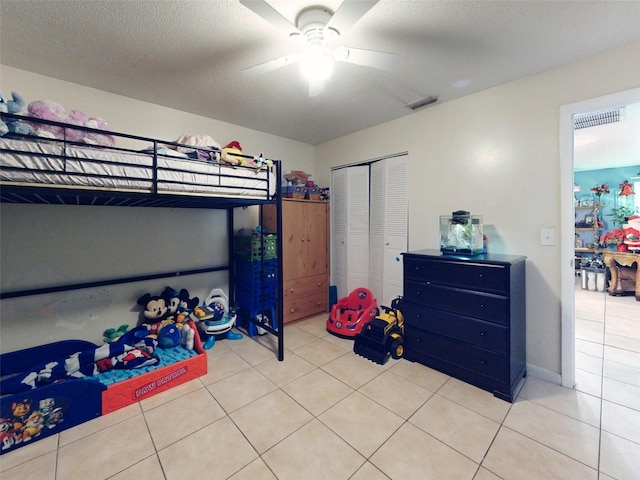 bedroom with a closet, ceiling fan, and light tile flooring