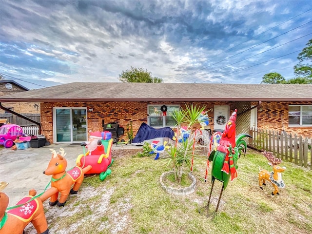 rear view of house with a lawn and a patio