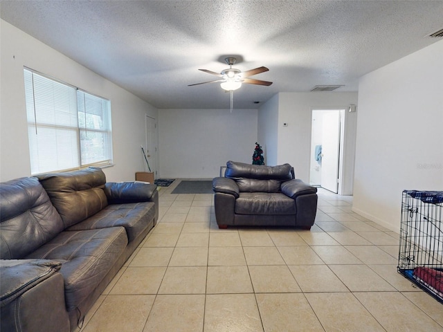 living room featuring light tile floors, a textured ceiling, and ceiling fan