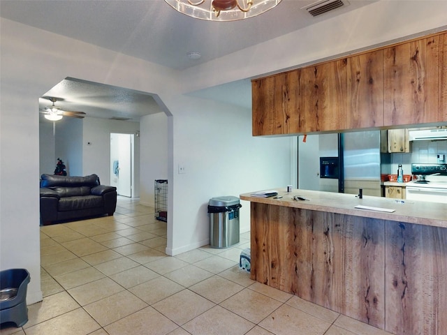 kitchen featuring backsplash, electric range, ceiling fan with notable chandelier, light tile flooring, and stainless steel fridge with ice dispenser