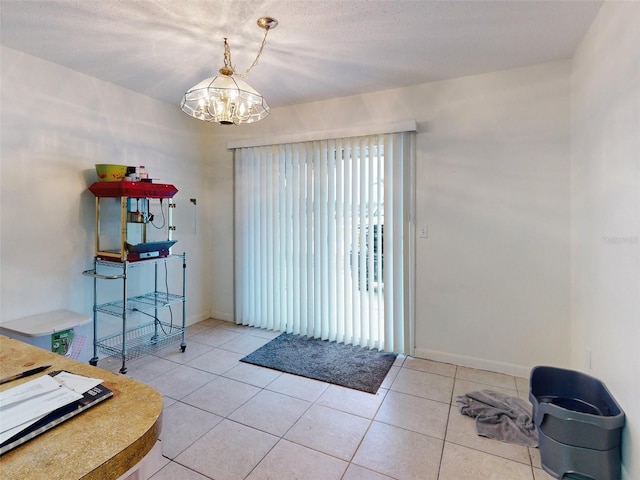 doorway to outside with light tile flooring, a textured ceiling, and an inviting chandelier