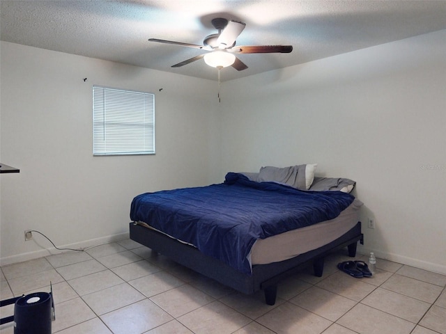 tiled bedroom with ceiling fan and a textured ceiling