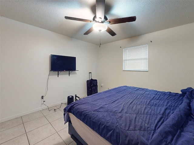 bedroom with light tile floors, ceiling fan, and a textured ceiling