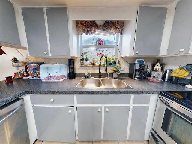 kitchen featuring tasteful backsplash, sink, gray cabinets, and dishwasher