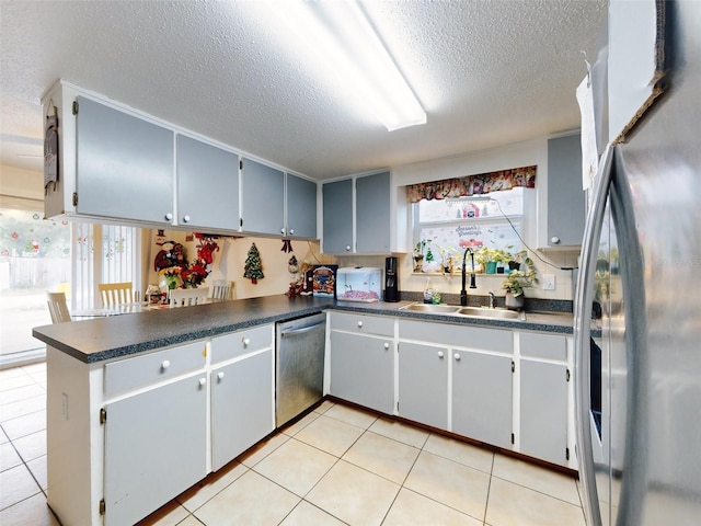 kitchen featuring stainless steel appliances, light tile floors, gray cabinets, and sink