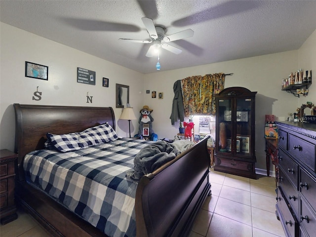 bedroom with a textured ceiling, ceiling fan, and light tile flooring