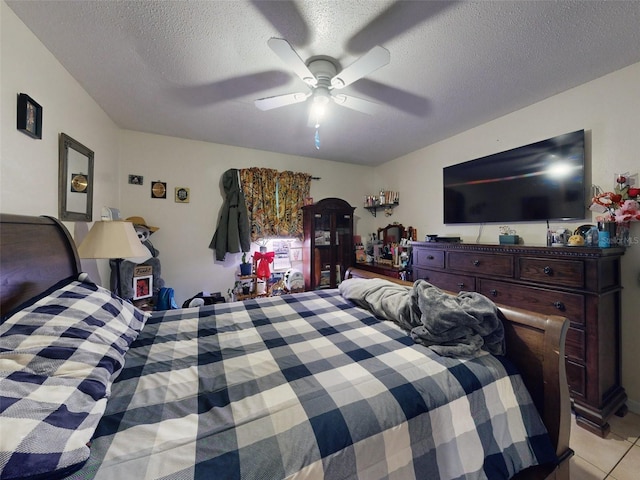 bedroom featuring light tile floors, a textured ceiling, and ceiling fan