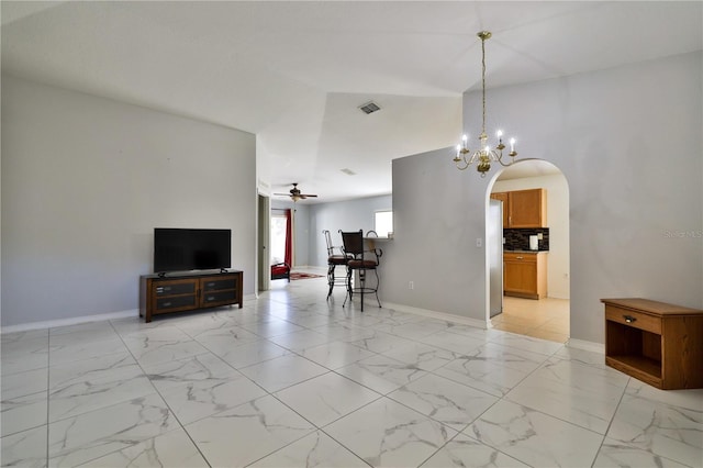 unfurnished living room with light tile floors and ceiling fan with notable chandelier