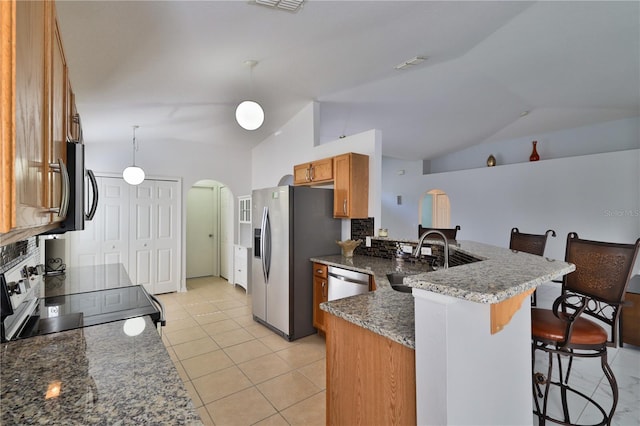 kitchen with decorative light fixtures, dark stone counters, sink, and lofted ceiling